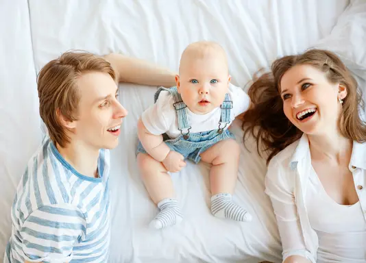 Haus-Familie-Wohnen-Serie-2 Mutter, Vater und Kind liegen auf dem Bett.
